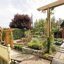 Artisan gates open to pebble and brick pathways that lead around the house to a series of secret gardens. The sound of water falling into the stone pond reduces street noises to a whisper.